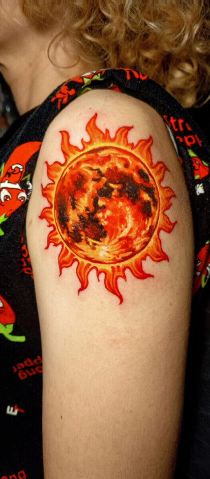 Татуировка солнца в стиле неотрадишнл на плече