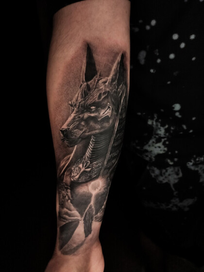 Реалистичная татуировка Анубиса на предплечье в стиле Black&Grey