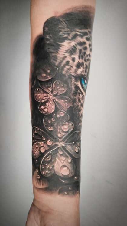 Тату леопарда и цветов с каплями росы в стиле реализм на предплечье