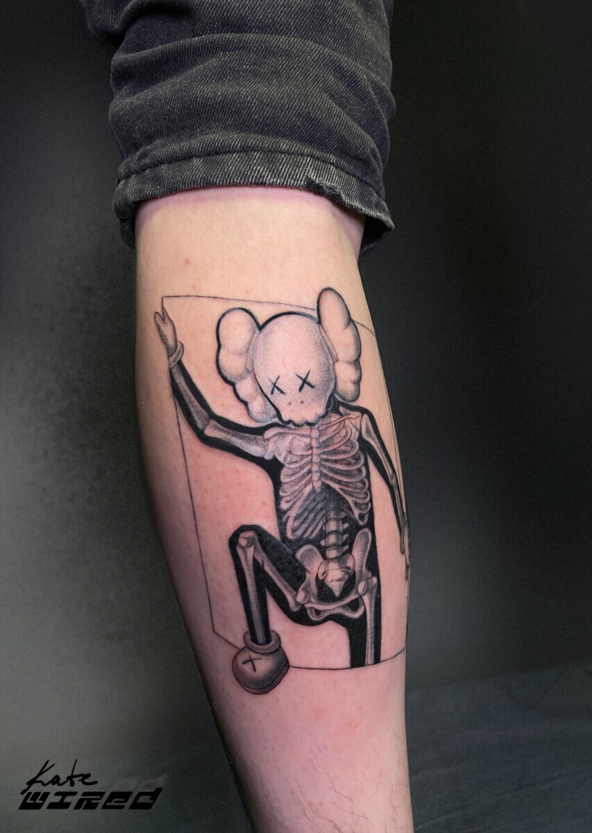 Татуировка скелета KAWS Companion на голени в стиле графика