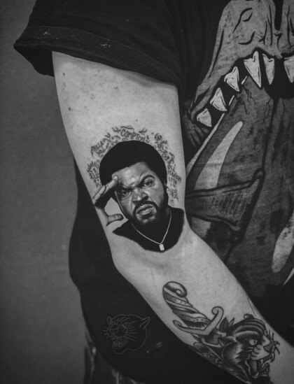 Татуировка с портретом Ice Cube в стиле реализм на бицепсе