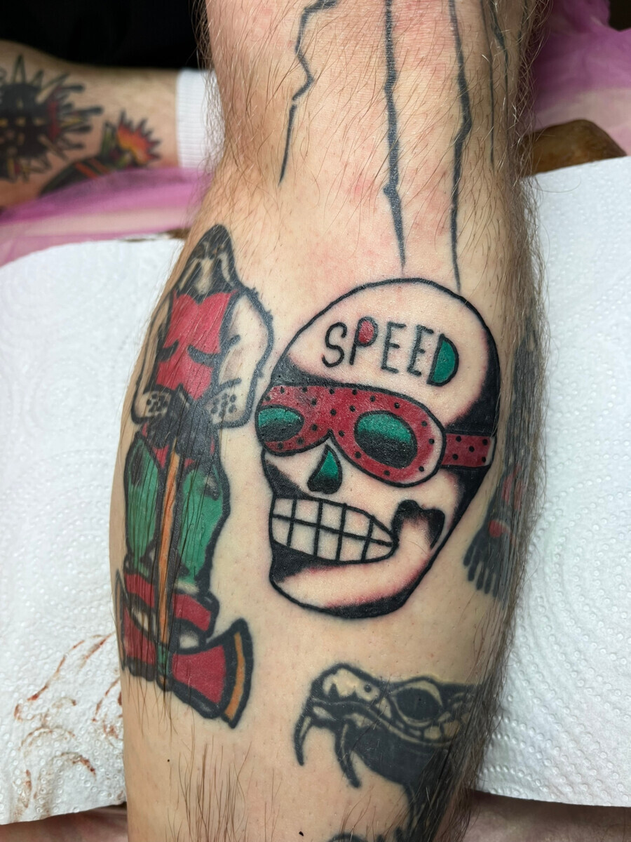Тату черепа в гоночных очках и надписью Speed в стиле олд скул