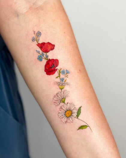 Цветная татуировка с маками и ромашками на предплечье