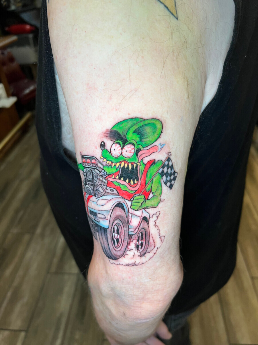 Цветная татуировка Рэт Финк (Rat Fink) на машине на плече