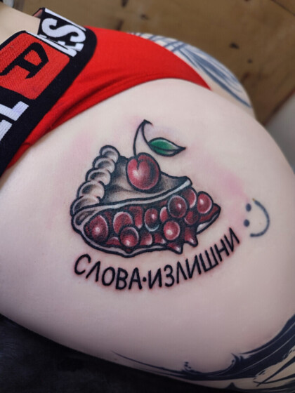 Цветная татуировка вишневого пирога с надписью на бедре