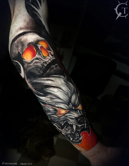 Тату на предплечье: череп и волк с огненными глазами