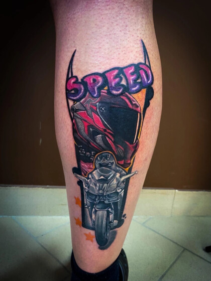 Яркая цветная татуировка на голени с мотоциклом, шлемом и надписью Speed