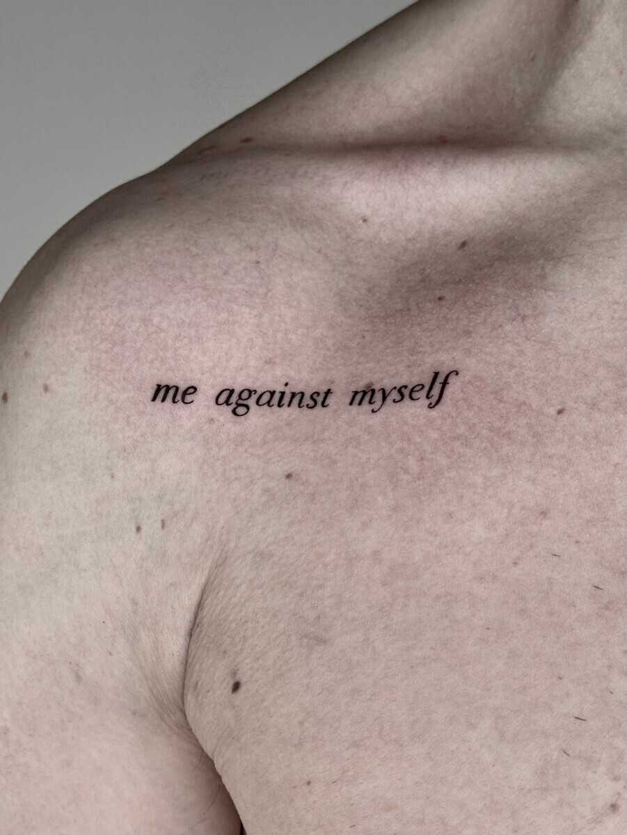 Минималистичная тату-надпись me against myself на ключице