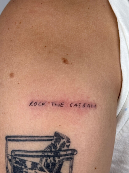 Минималистичная тату-надпись Rock the Casbah на плече