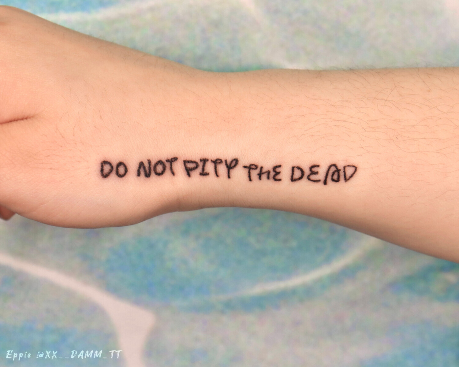 Тату надпись на английском «Do not pity the dead» на ребре ладони
