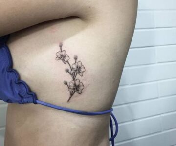 Фото тату орхидеи на ребрах девушки