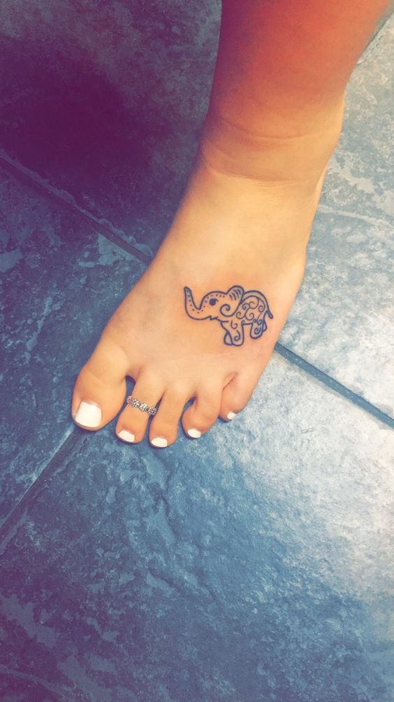 Фото татуировки слона в индийском стиле на ступне девушки