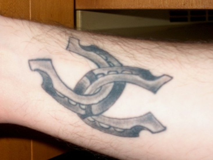 Тату на предплечье парня - две подковы