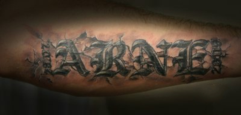 Тату на предплечье у парня - камень с надписью