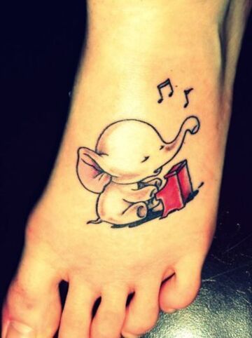 Тату на ступне девушки - ноты и слоник