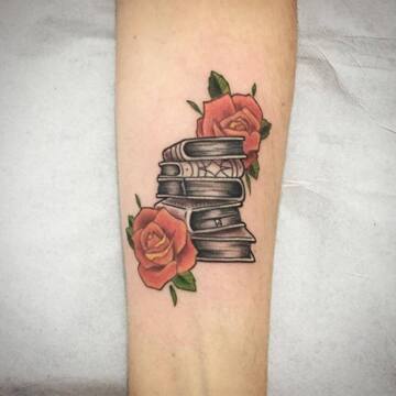 Татуха книг с розами на предплечье парня